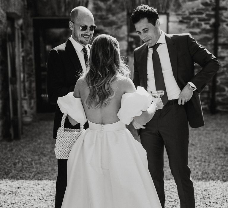 Bride holding a pearl handbag in a backless wedding dress with puff sleeves 