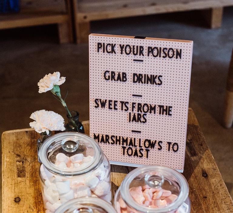 Pinboard sign with jars of pink sweets and carnations