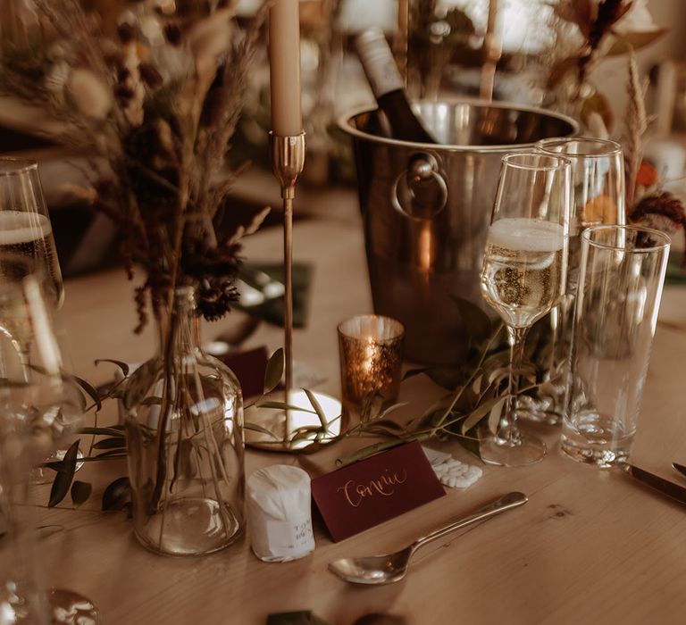 Soft autumnal wedding tablescape with neutral taper candles and gold detailing 