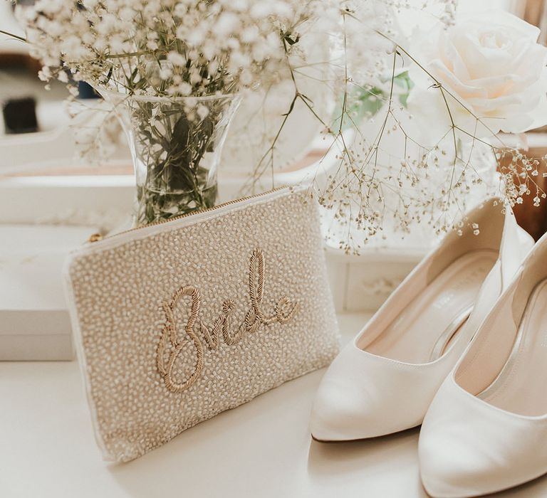 White gypsophila and roses with a white beaded Bride clutch bag and plain white heels 