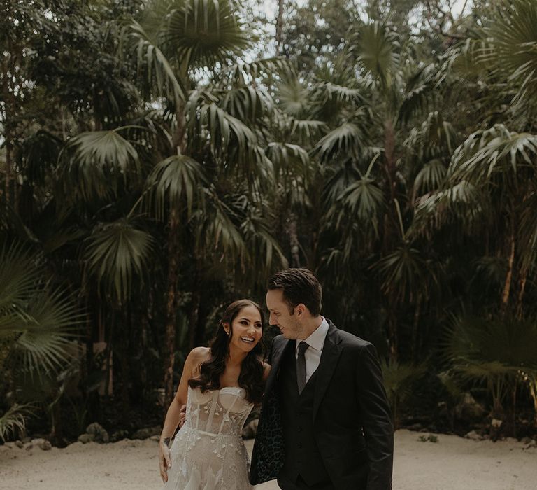 Bride & groom walk along the beach during couples portraits outdoors for cenote wedding in Tulum