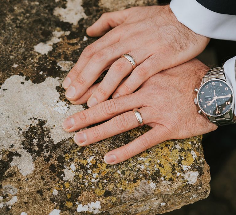 Grooms wearing silver wedding rings 