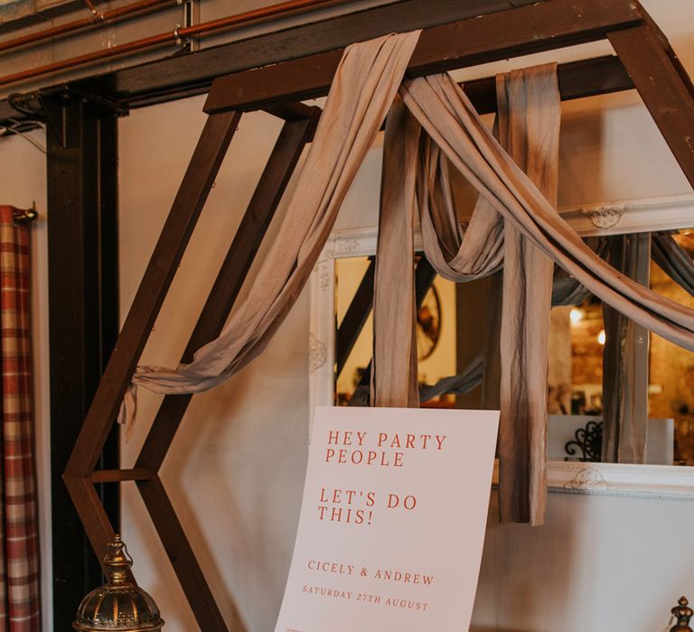 Pale pink welcome and order of the day wedding sign with large old fashioned lanterns filled with pillar candles 