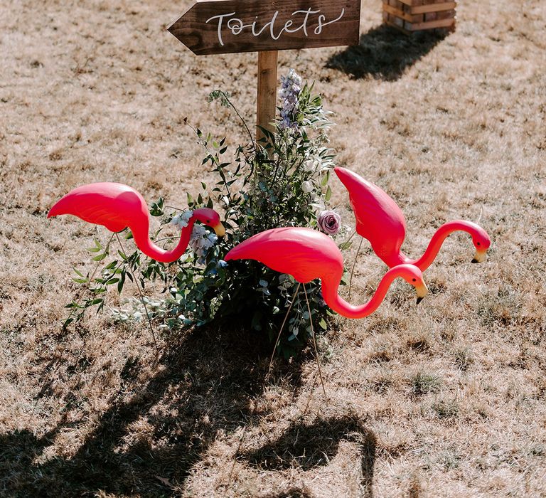 Wooden wedding sign with lawn flamingo decorations for Ibiza pool party theme 