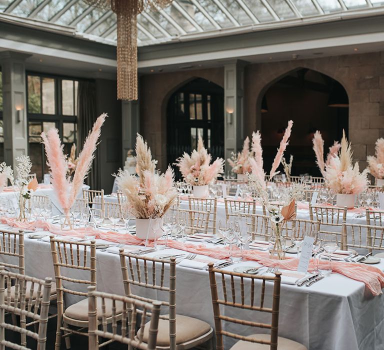 Pink and white pampas grass centrepiece decor lining the tables for the reception at Hampton Manor venue 