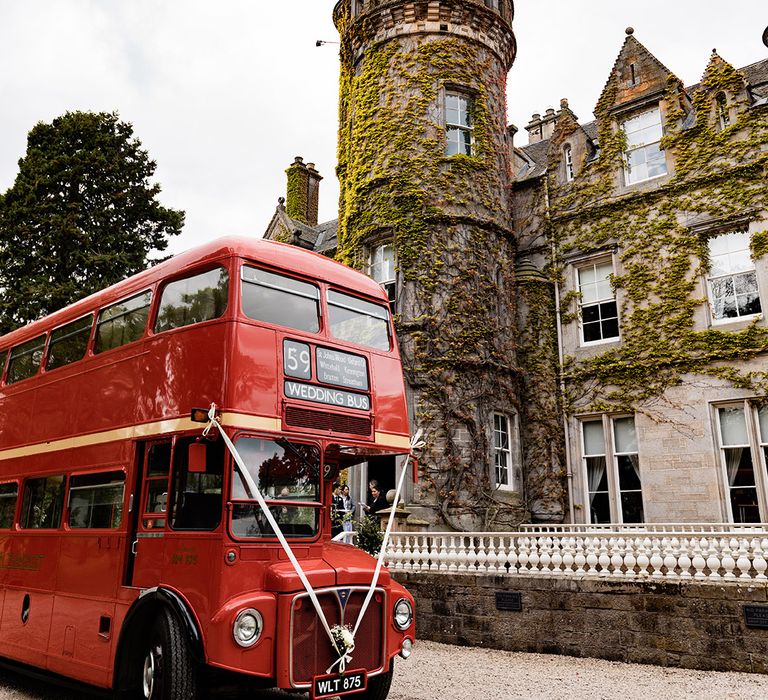 Red London wedding bus tied with white silk ribbon