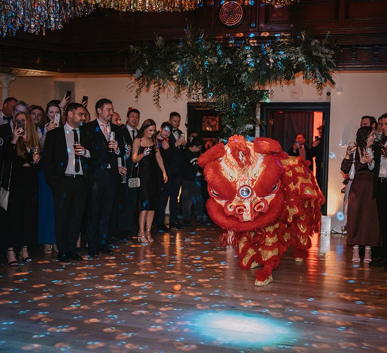 Wedding guests watching Chinese Lion Dance at multicultural Christmas wedding in London