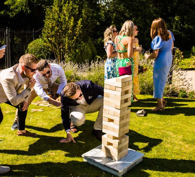 Wedding guests play jenga for outdoor wedding entertainment and games 