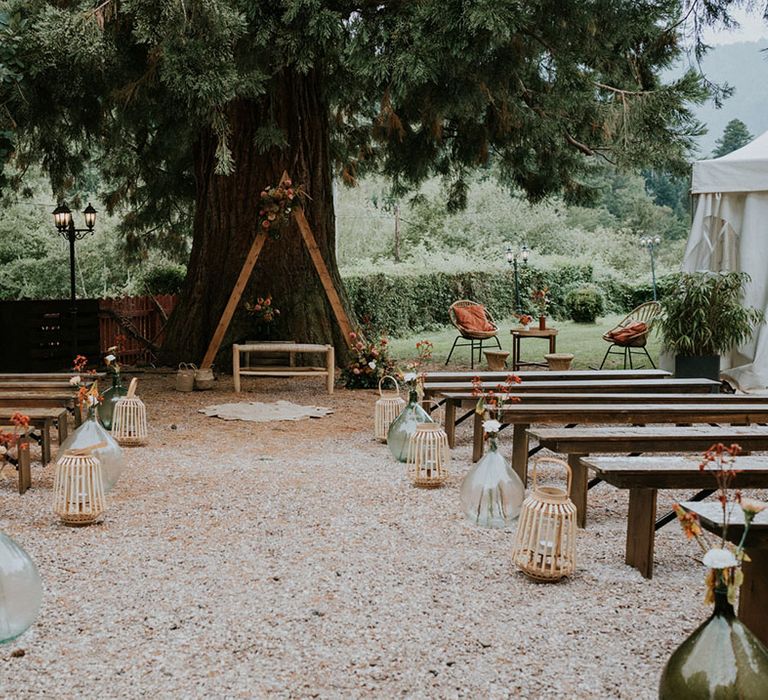 Outdoor ceremony aisle wedding decor with wicker baskets, wildflowers and wooden frame altar