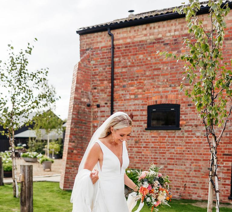 Bride in Savin London wedding dress with white bow wedding shoes and dainty pearl earrings 