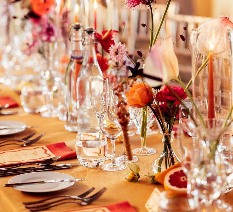 Pink and orange wedding flower decorations in glass vases 