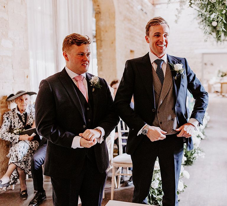 Groom and best man standing together with three piece suit with navy spotted tie 