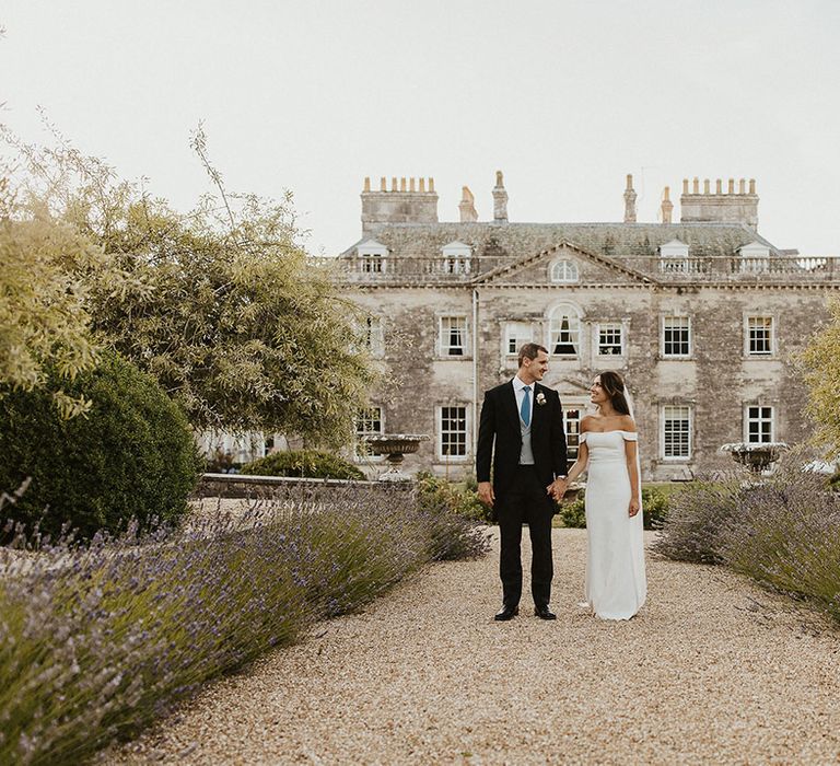 Wedding photograph of the bride and groom posing together at their classic summer wedding