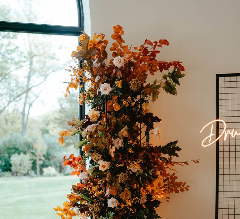 Wedding flower column arrangement with autumn leaves and roses for autumn theme wedding 