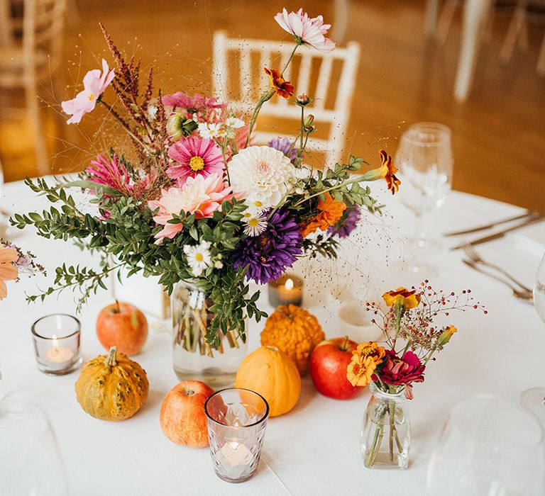 Colourful wedding table centrepiece with fruits, mini pumpkins and seasonal flowers 