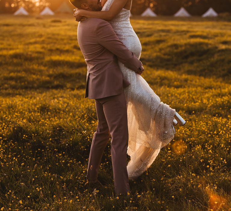 Bride and groom shares a passionate embrace during golden hour 