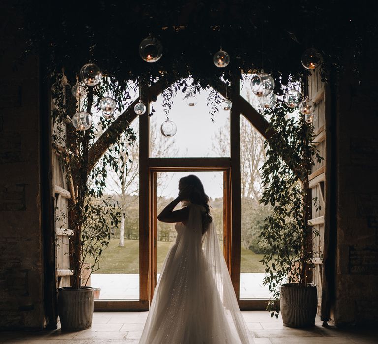 The bride wears a sparkly wedding dress by Eva Lendel with wavy hair at Stone Barn wedding venue 