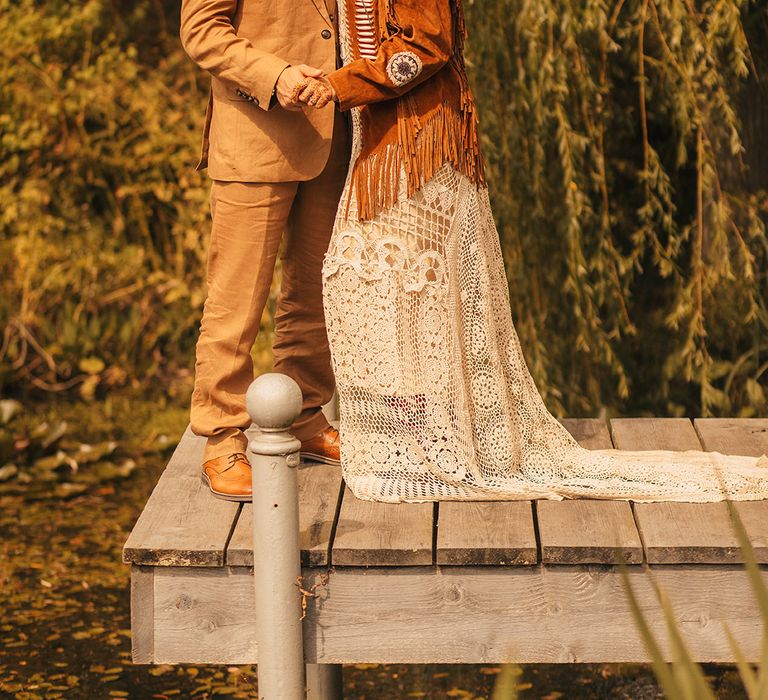 Groom wearing suede hat with bride in suede fringe jacket at vintage wedding 