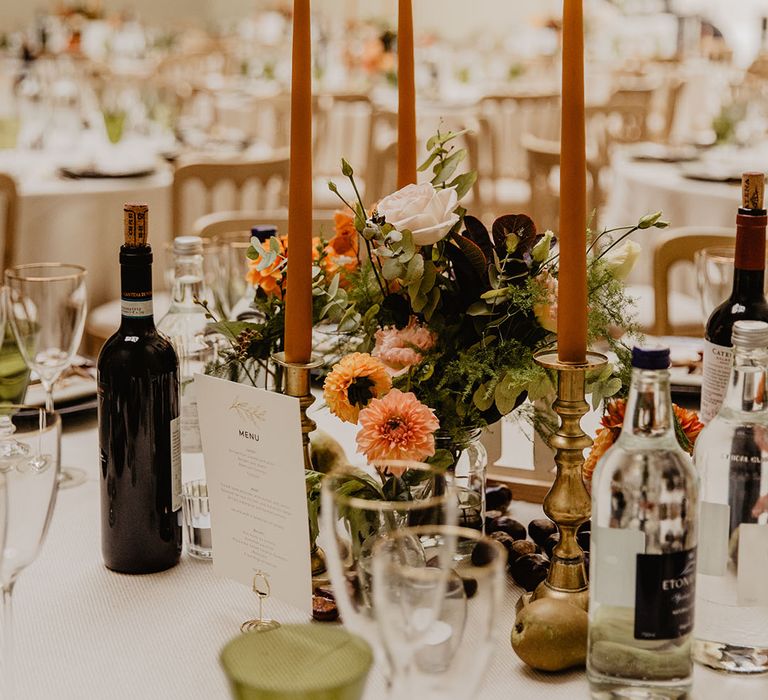 Neutral wedding tablescape with green coloured glassware, taper candlesticks and pretty flowers 