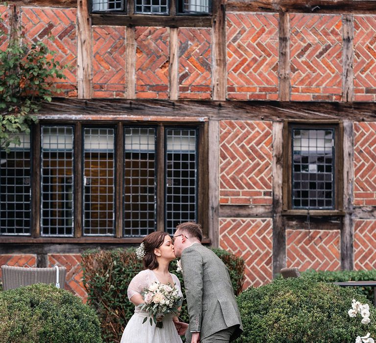 Couple portrait of the bride and groom kissing at their Langshott Manor wedding 