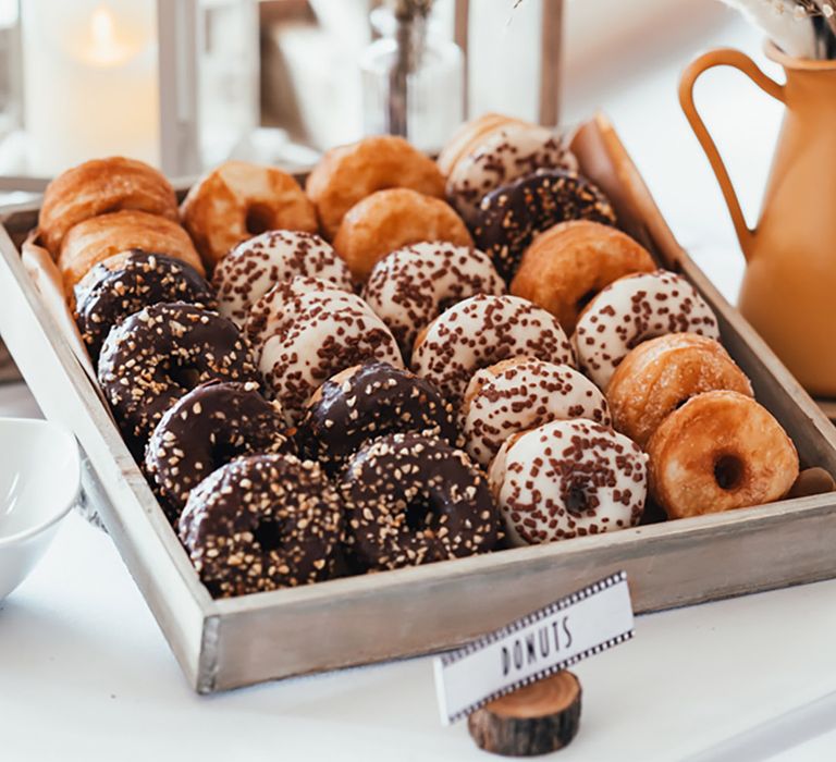 Wooden tray filled with doughnuts for wedding dessert table 