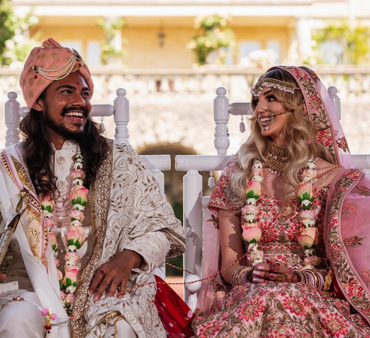 Bride and groom laughing at Hindu wedding ceremony 