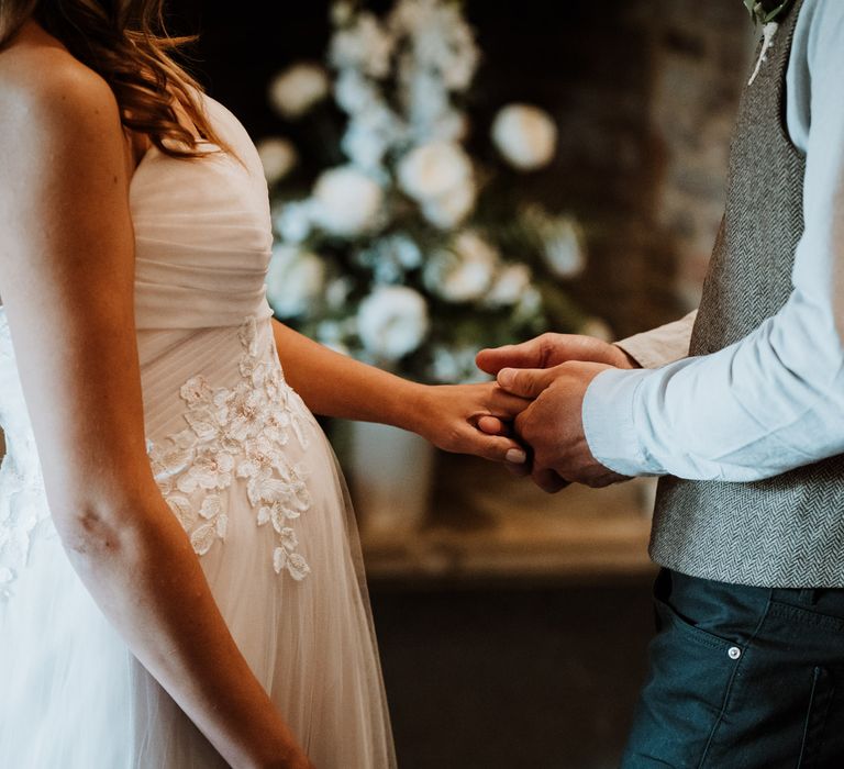 Bride and groom holding hands and exchanging vows during their intimate ceremony 