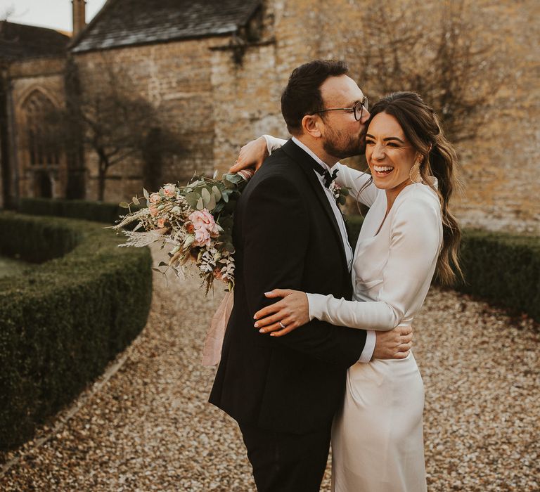 Bride & groom embrace on wedding day at Sherborne School