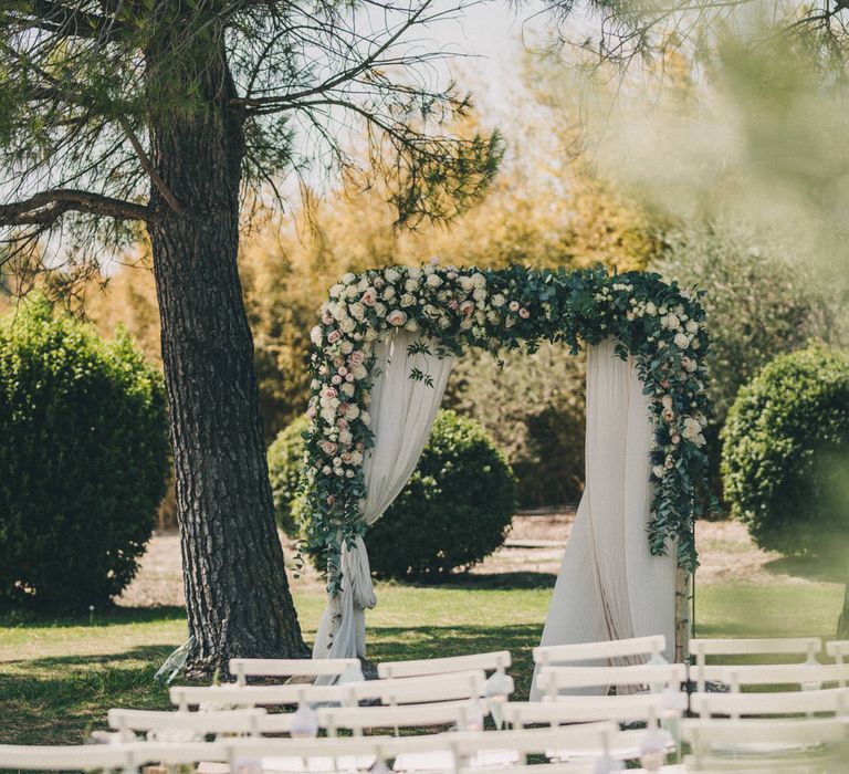 Wedding altar fabric and floral decoration at outdoor wedding ceremony