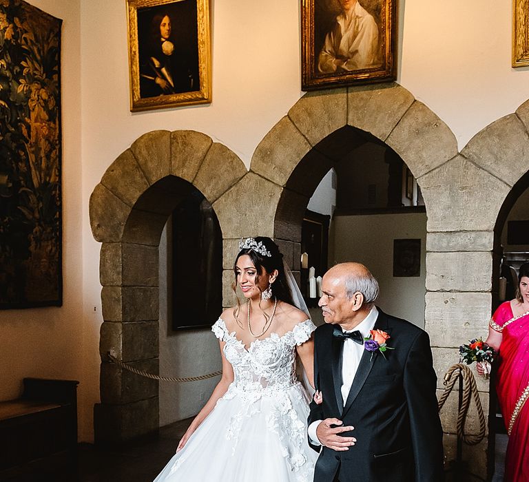 Leeds castle wedding ceremony bridal entrance with the father of the bride in a tuxedo walking his daughter down the aisle 