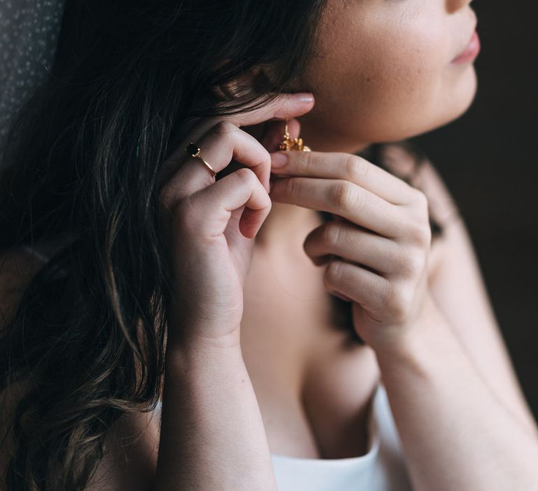 The bride fits her earrings from Skye's Purple Cloud Shop