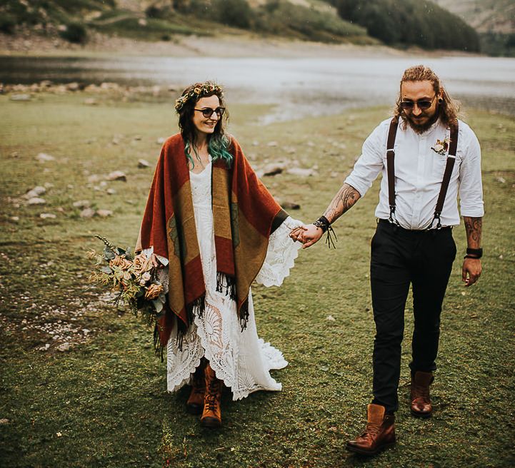 Bride & groom walk together with bride wearing shawl after wedding ceremony