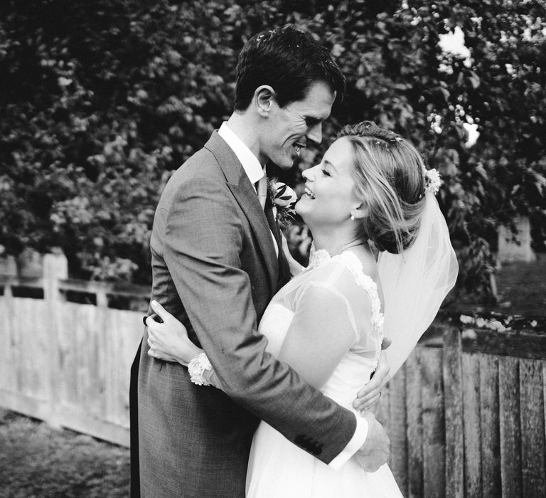 Bride & groom kiss outdoors whilst bride wears long sleeved gown