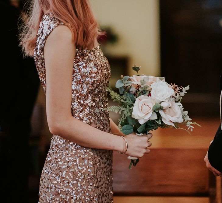 Bride in a pink sparkly wedding dress holding a pink and white rose bouquet at the intimate registry office wedding 