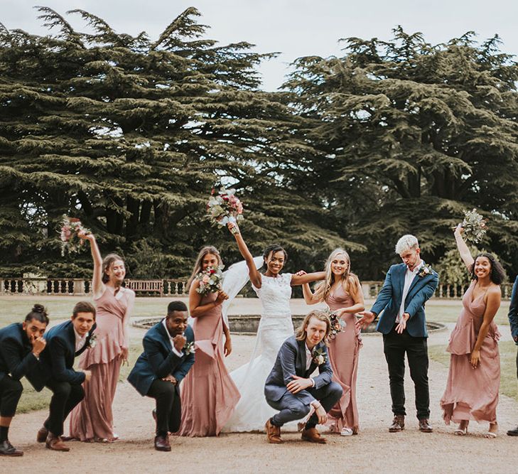 Wedding party portrait with groomsmen in blue suits and bridesmaids in pink dresses 