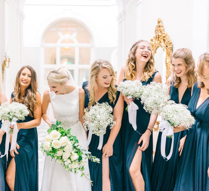 Bridesmaids wearing floor length chiffron navy bridesmaid dresses with plunge neckline, holding gypsophila bouquets | ASOS Dresses | Sarah-Jane Ethan Photography