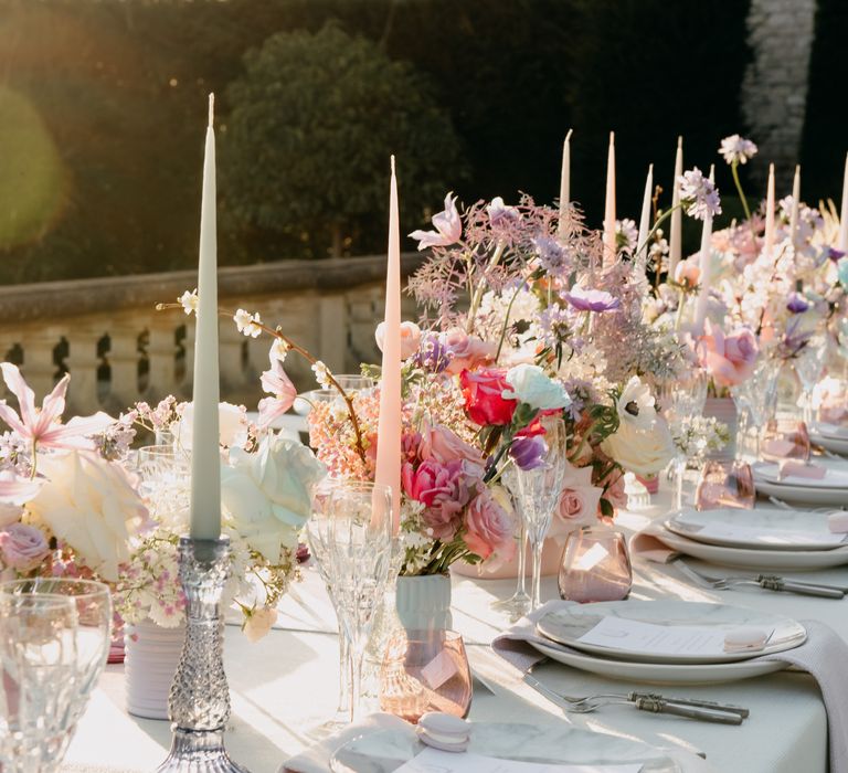 Pastel tablescape with white candles lining the table