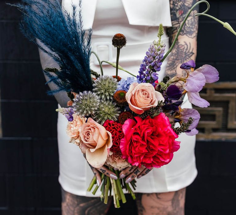 Bright red, purple and teal jewel wedding bouquet with roses, pampas grass and stocks 