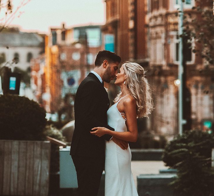 Intimate bride and groom portrait with bride in a slip wedding dress and groom in a tuxedo 