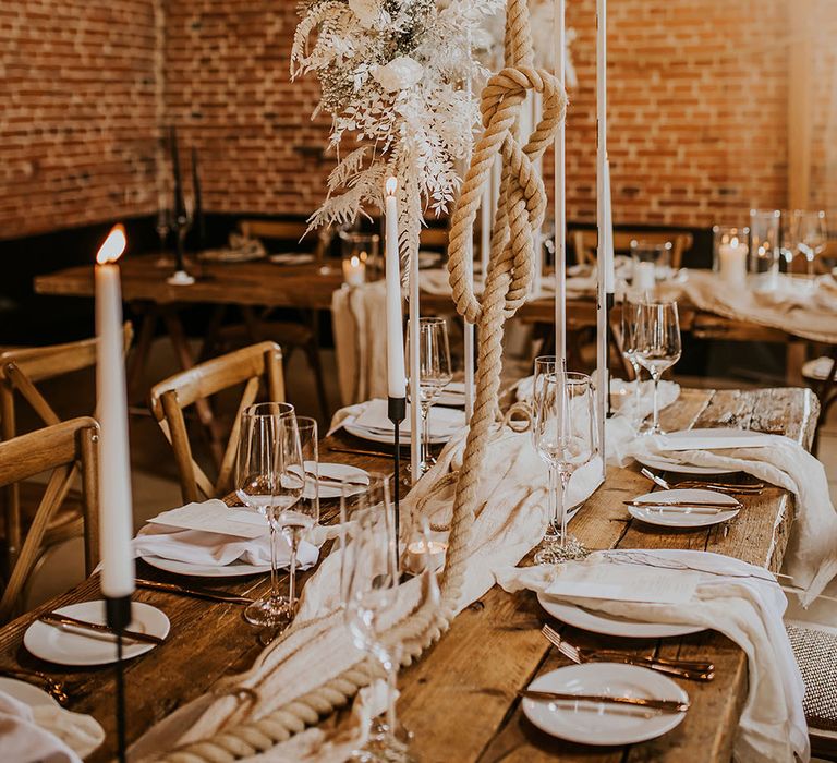 Tall centrepiece wedding decor with rope and white floral arrangement 