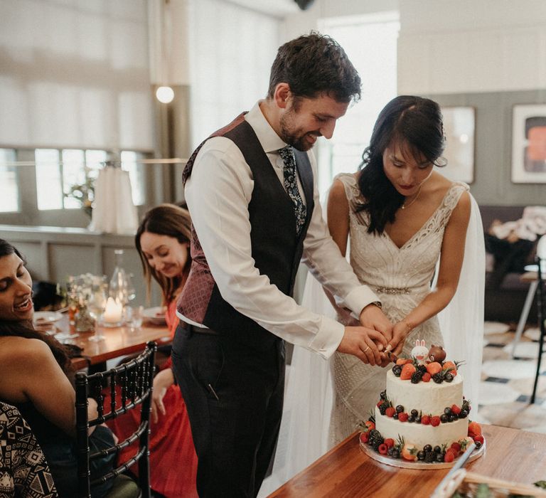 Bride and groom cutting into their wedding cake