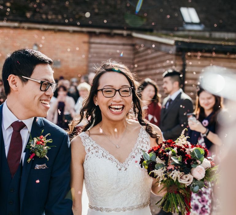 Bride & groom walk through confetti on wedding day