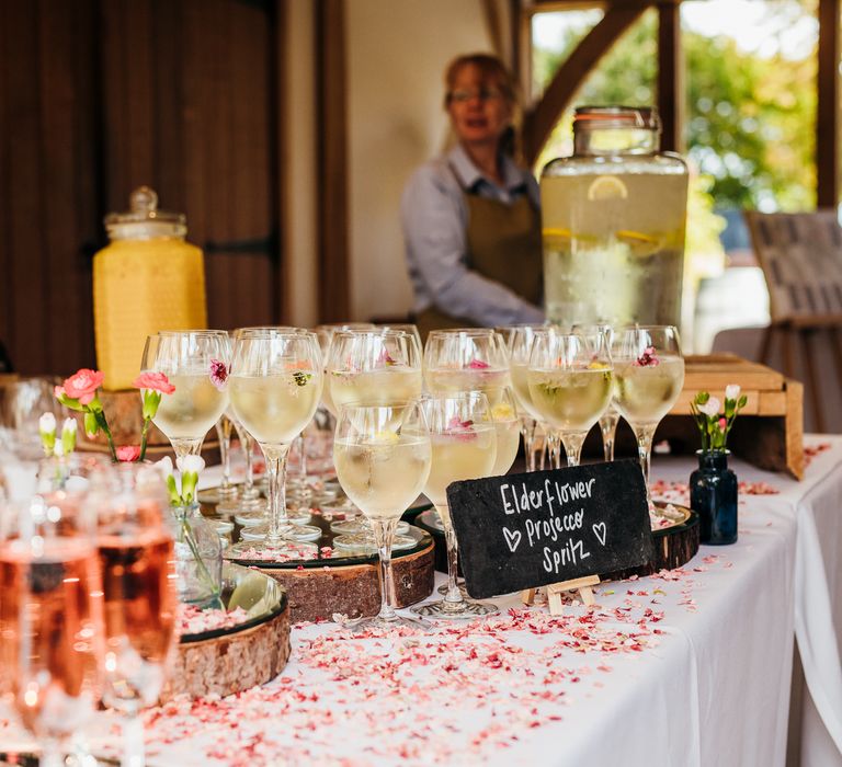 Elderflower Prosecco in wine glasses on table covered with dried confetti petals