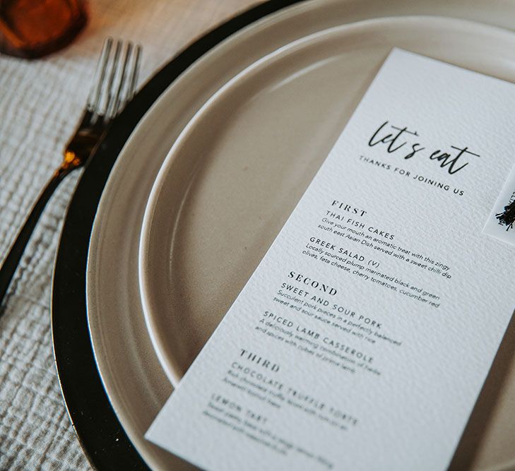 Let's eat menu card with black font and tassel decor 