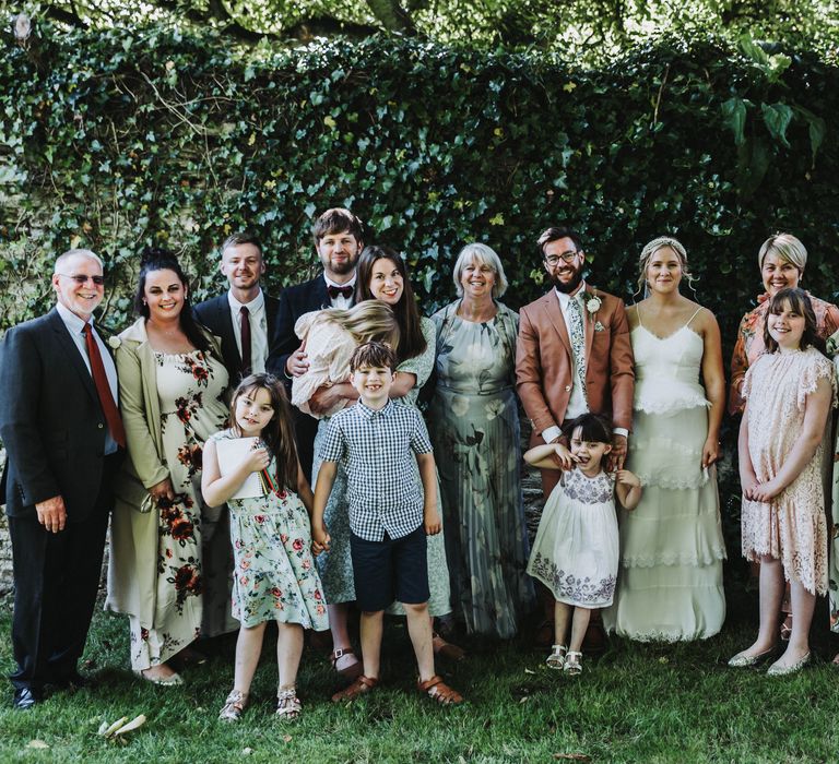 Wedding party gather for photos outdoors with one another at Treseren in Cornwall 