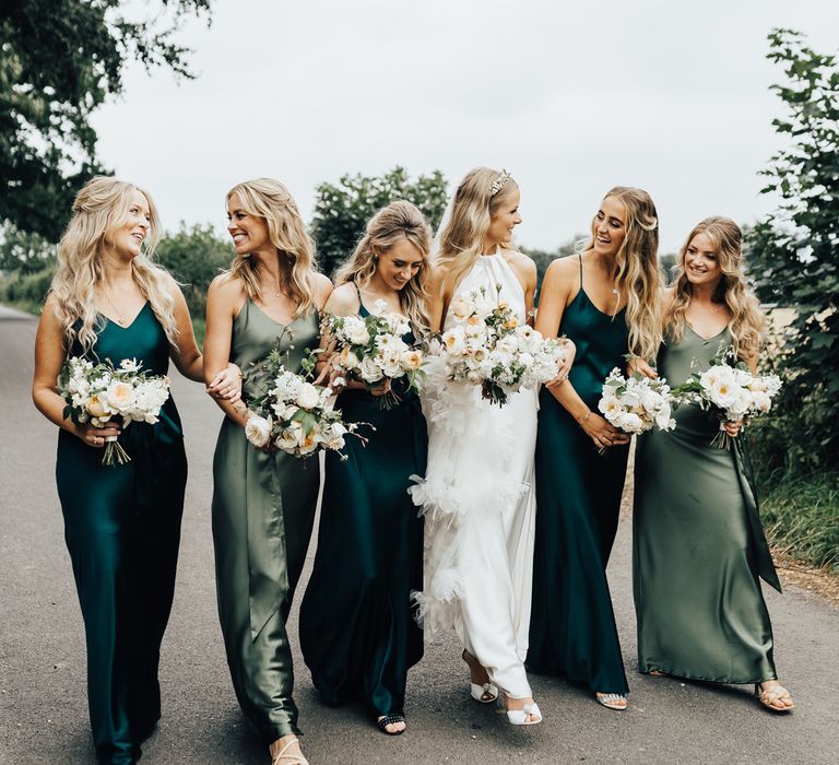 Bridesmaids in different coloured green Rewritten satin bridesmaid dresses 