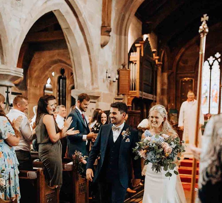 Bride and groom walk up the aisle after ceremony