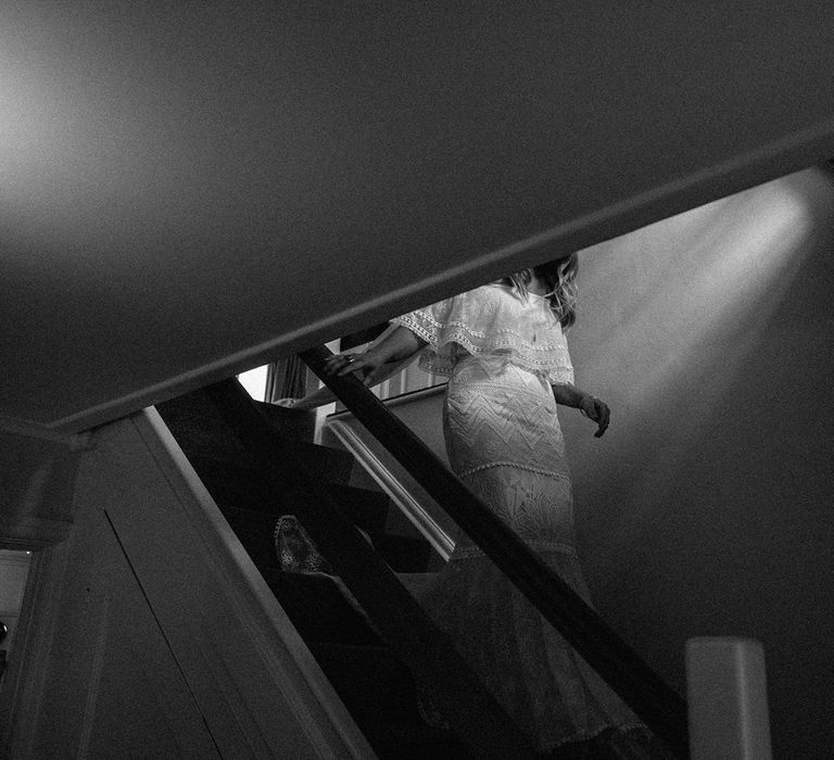 Bride in Grace Loves Lace Bardot wedding dress walking down the stairs before Isle of Wight wedding with macrame wedding decor