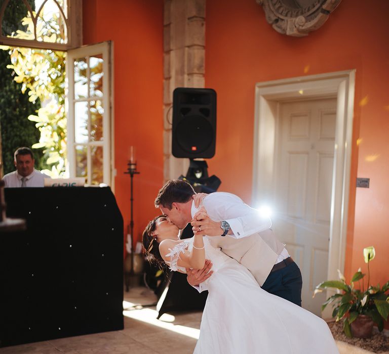 Groom dips his bride during dance on their wedding day