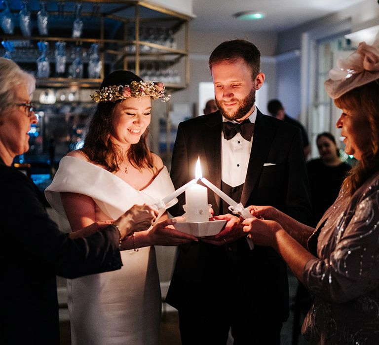 Bride & groom have candle lit during Ukrainian tradition at Hampton Court Palace wedding